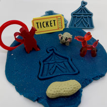 Load image into Gallery viewer, Playdough with circus-themed items including a ticket, red balloon animals, and a tent on a white background.